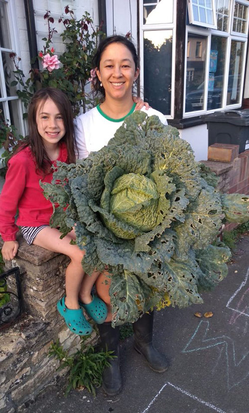 Michelle Aris, an advanced acupuncturist in London, with her daughter and a giant cabbage